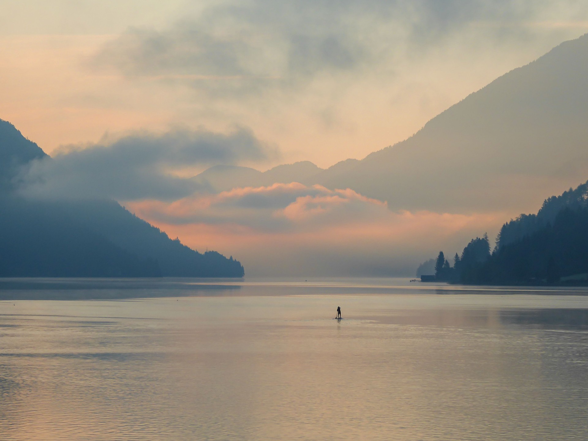 Weissensee - A stand up paddling man towards the sunset Weissensee - A stand up paddling man towards the sunset